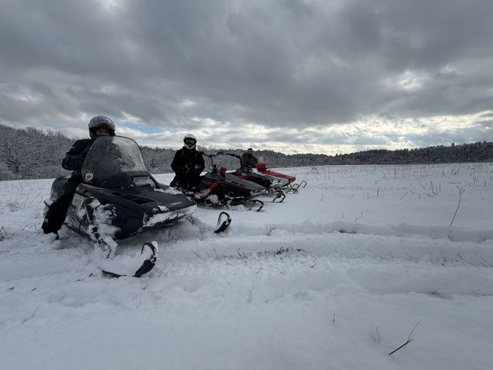 Riders crossing an open snow-covered field