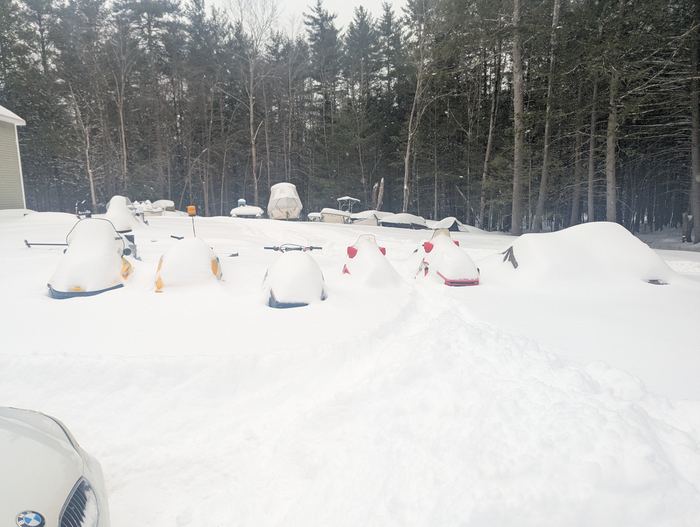 Snowmobiles buried under fresh snow after an overnight storm